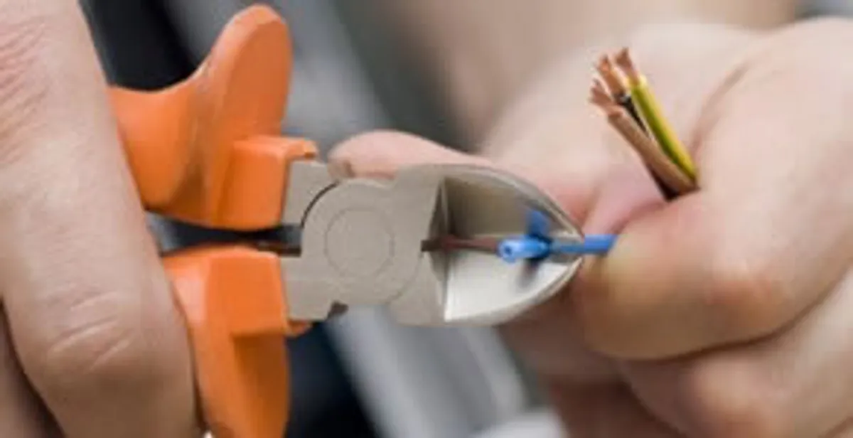 licensed electrician performing precise wire cutting and preparation during electrical service in Columbia, MO