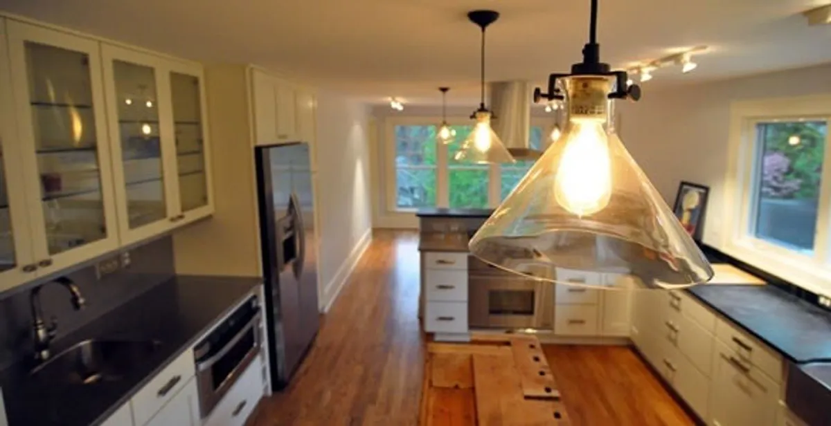 Residential electrician installing modern indoor light fixture in a home in Columbia, MO